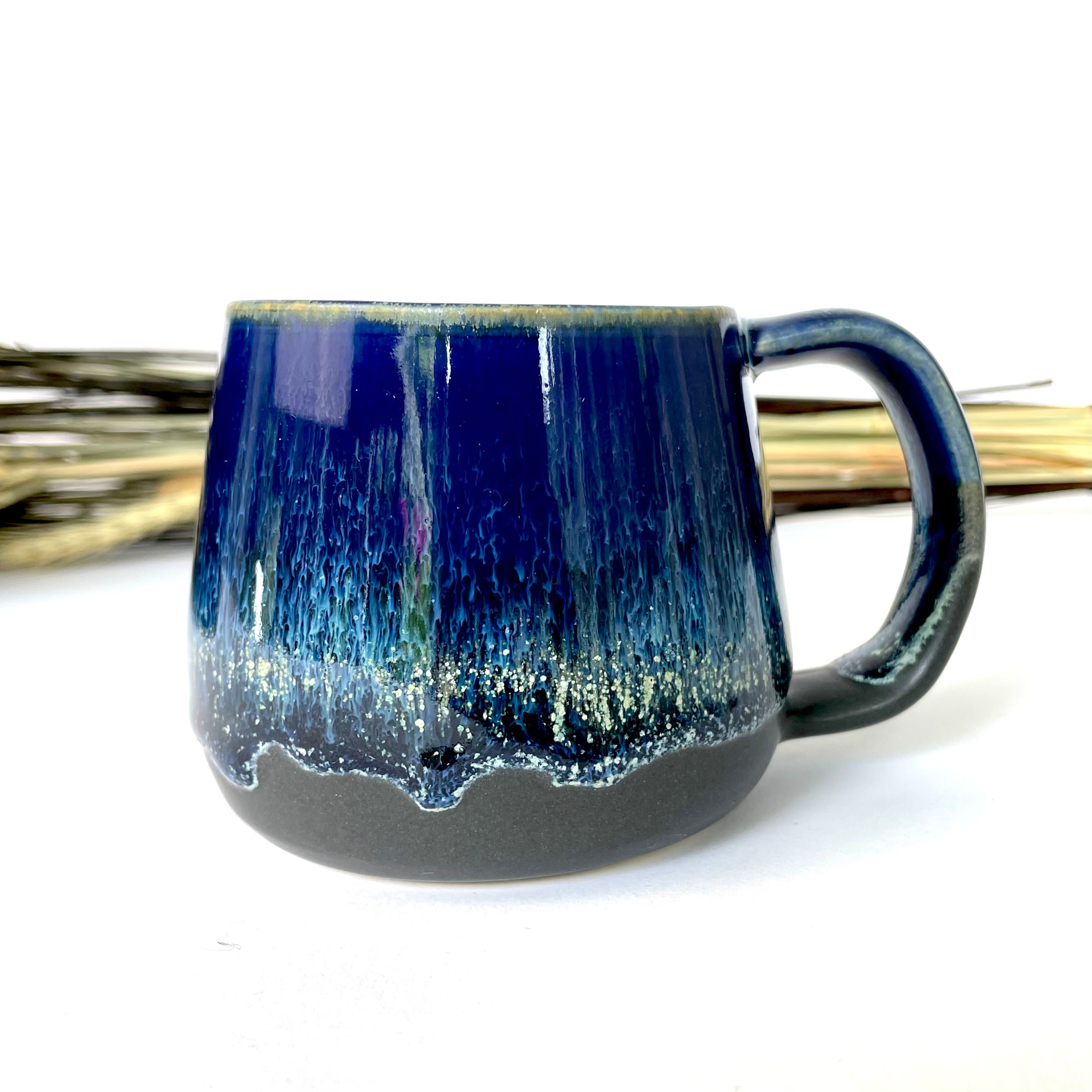 Handmade stoneware mug with a deep cobalt-blue drip glaze fading to a dark base