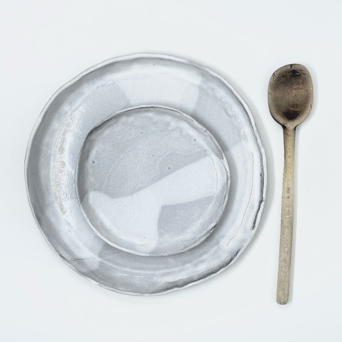 Pale translucent glazed plate paired with a spoon