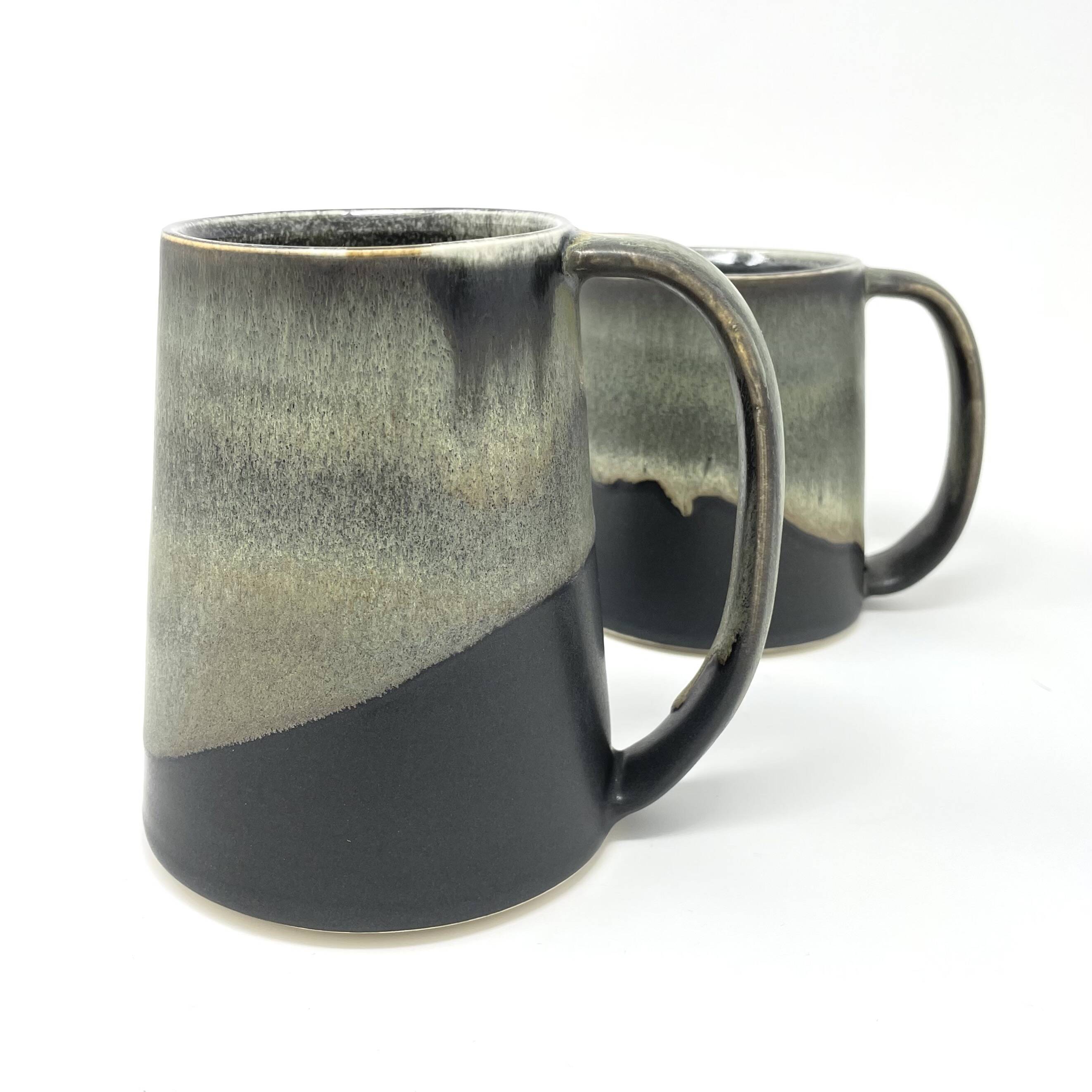 Two mugs with an olive-green glaze dipped over dark clay