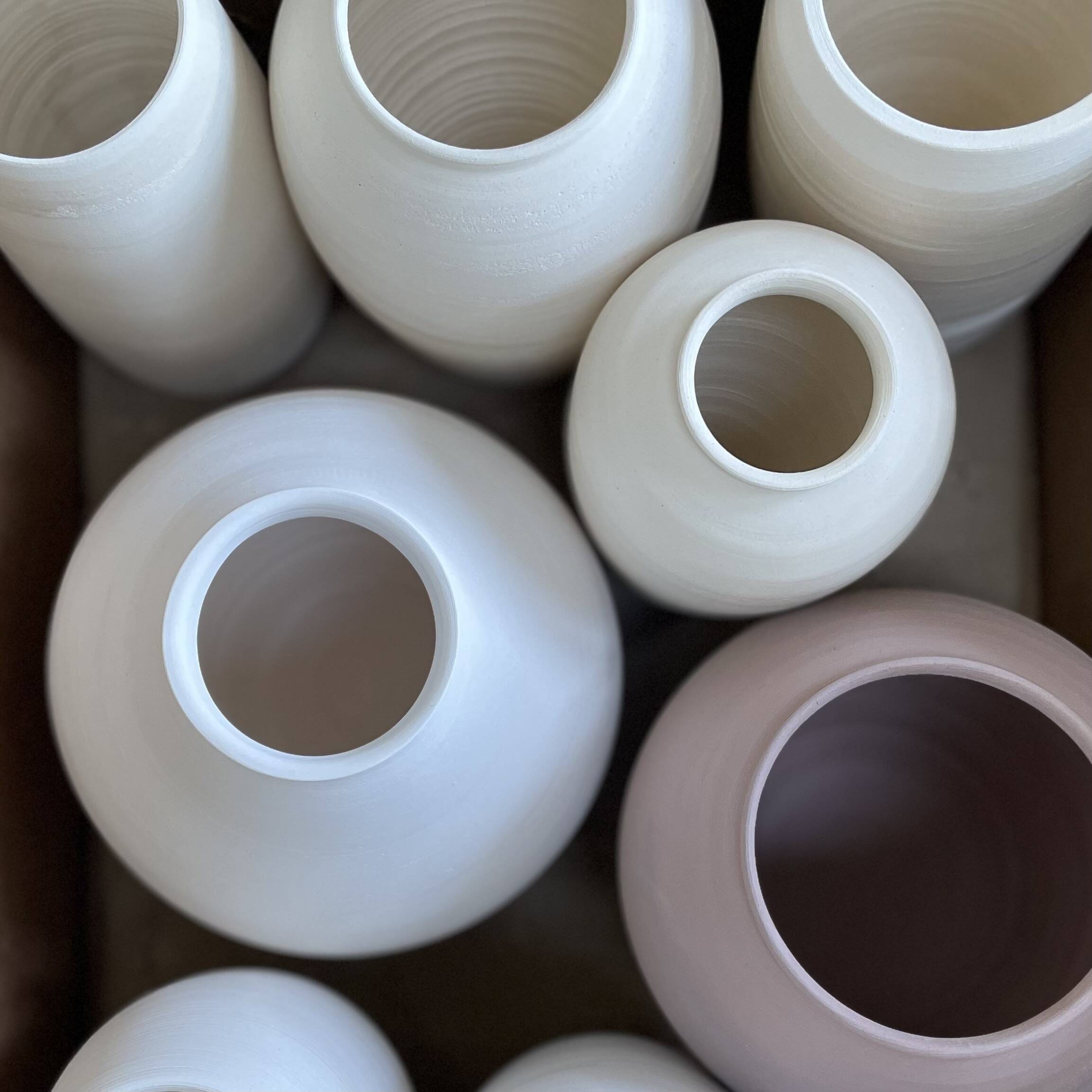 Cluster of rounded vases in white and mauve, seen from above